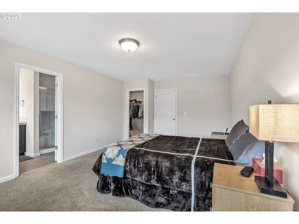 a bedroom with a bed and a view of kitchen