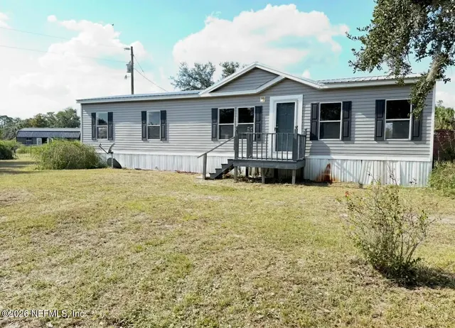 a front view of a house with a garden and yard
