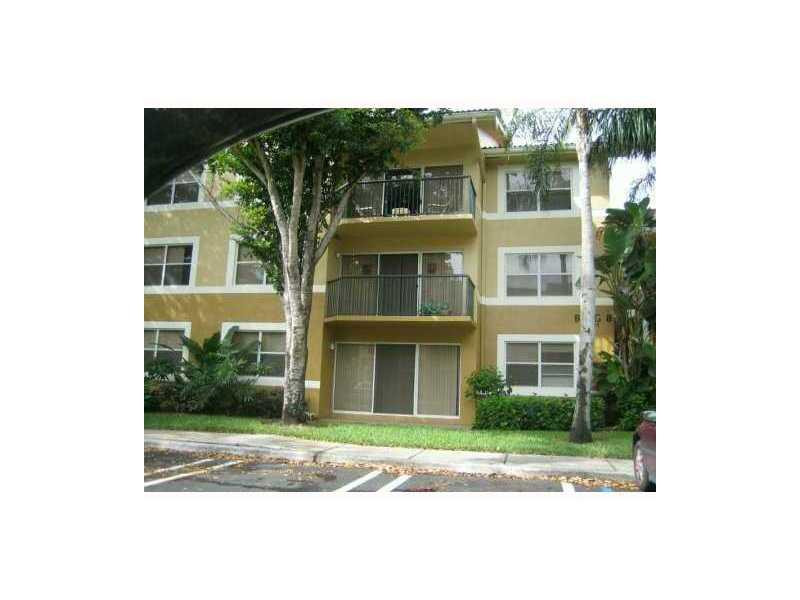 8977 Wiles Road, Unit 1052 Coral Springs, FL 33067 - Photo 1 of 8 a front view of a house with a yard
