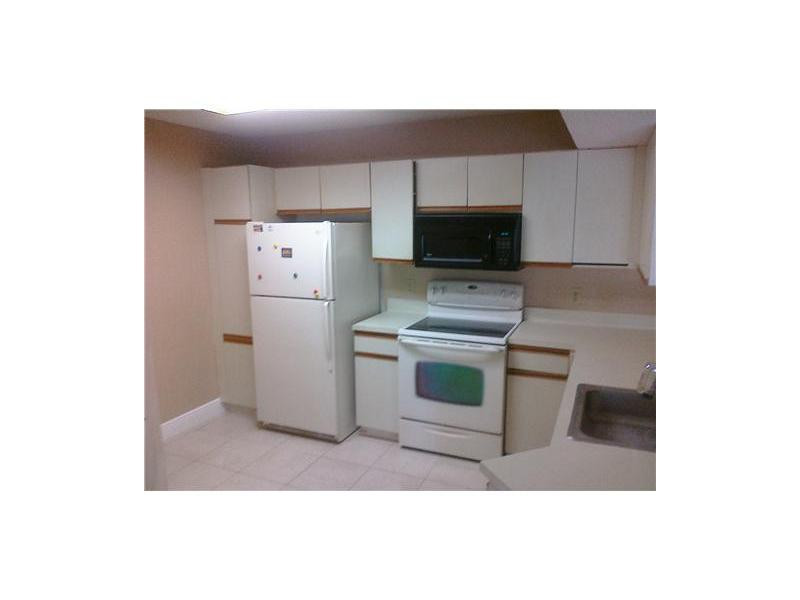 8977 Wiles Road, Unit 1052 Coral Springs, FL 33067 - Photo 5 of 8 a kitchen with a refrigerator and a stove
