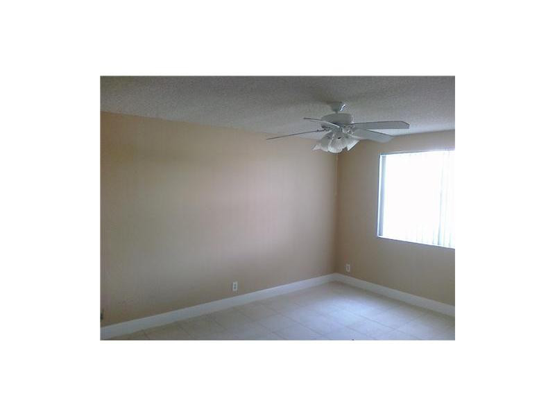 8977 Wiles Road, Unit 1052 Coral Springs, FL 33067 - Photo 7 of 8 a view of a big room with windows and chandelier fan