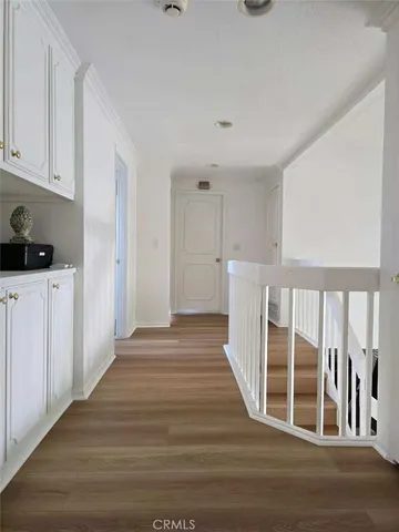 a view of a kitchen with wooden floor and electronic appliances