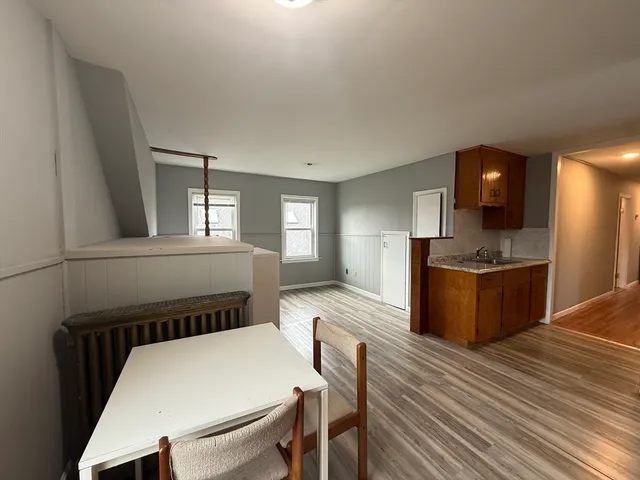 a kitchen with a table chairs sink and refrigerator