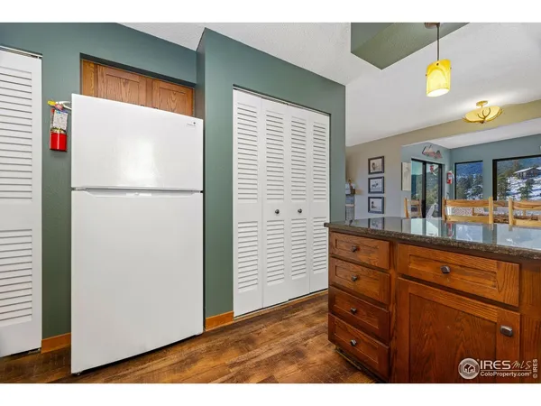 a view of kitchen with a refrigerator cabinets and wooden floor