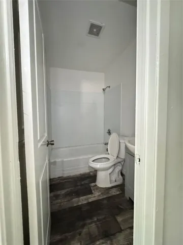 a white toilet sitting next to a bathroom sink