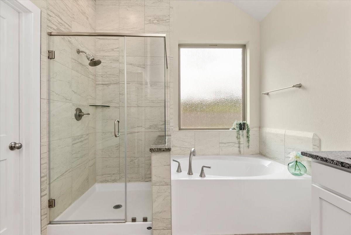 17814 Tree Of Heaven Conroe, TX 77385 - Photo 18 of 48 Luxurious primary bath with walk-in shower, soaking tub, and elegant tile finishes—perfect for relaxation.