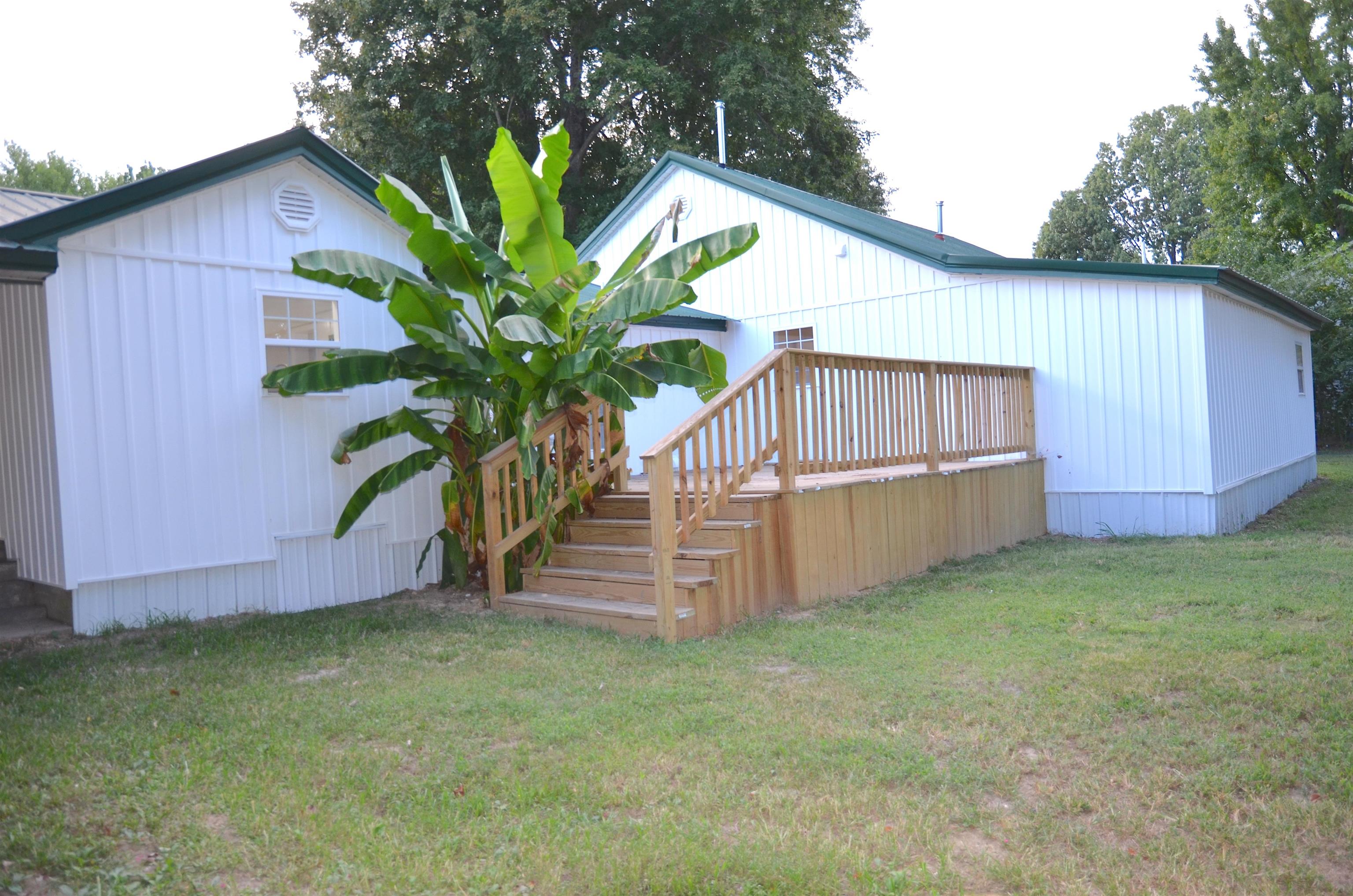2464 Edith-Nankipoo Road Ripley, TN 38063 - Photo 20 of 22 Wood deck with stairs and railing, white vertical siding, and a dark green metal roof