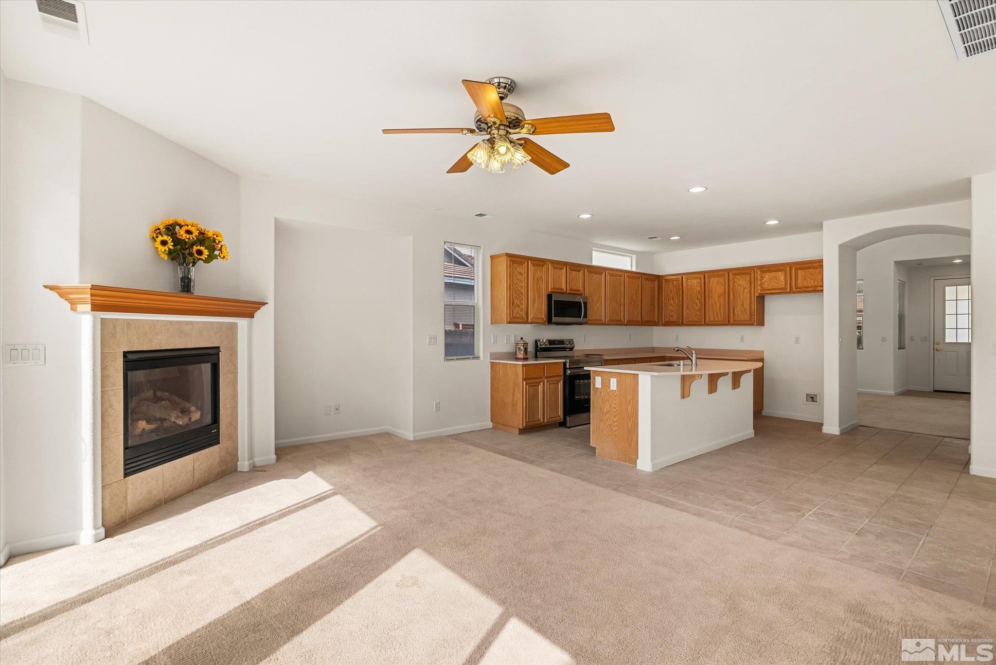 10555 Thistle Berry Court Reno, NV 89521 - Photo 10 of 35 a open kitchen with a stove top oven and fireplace