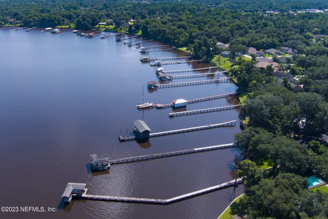an aerial view of a house with a yard and lake view