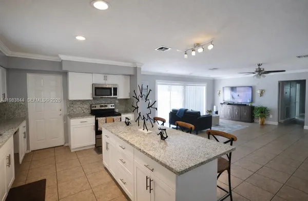 a kitchen with a sink a counter top space appliances and cabinets