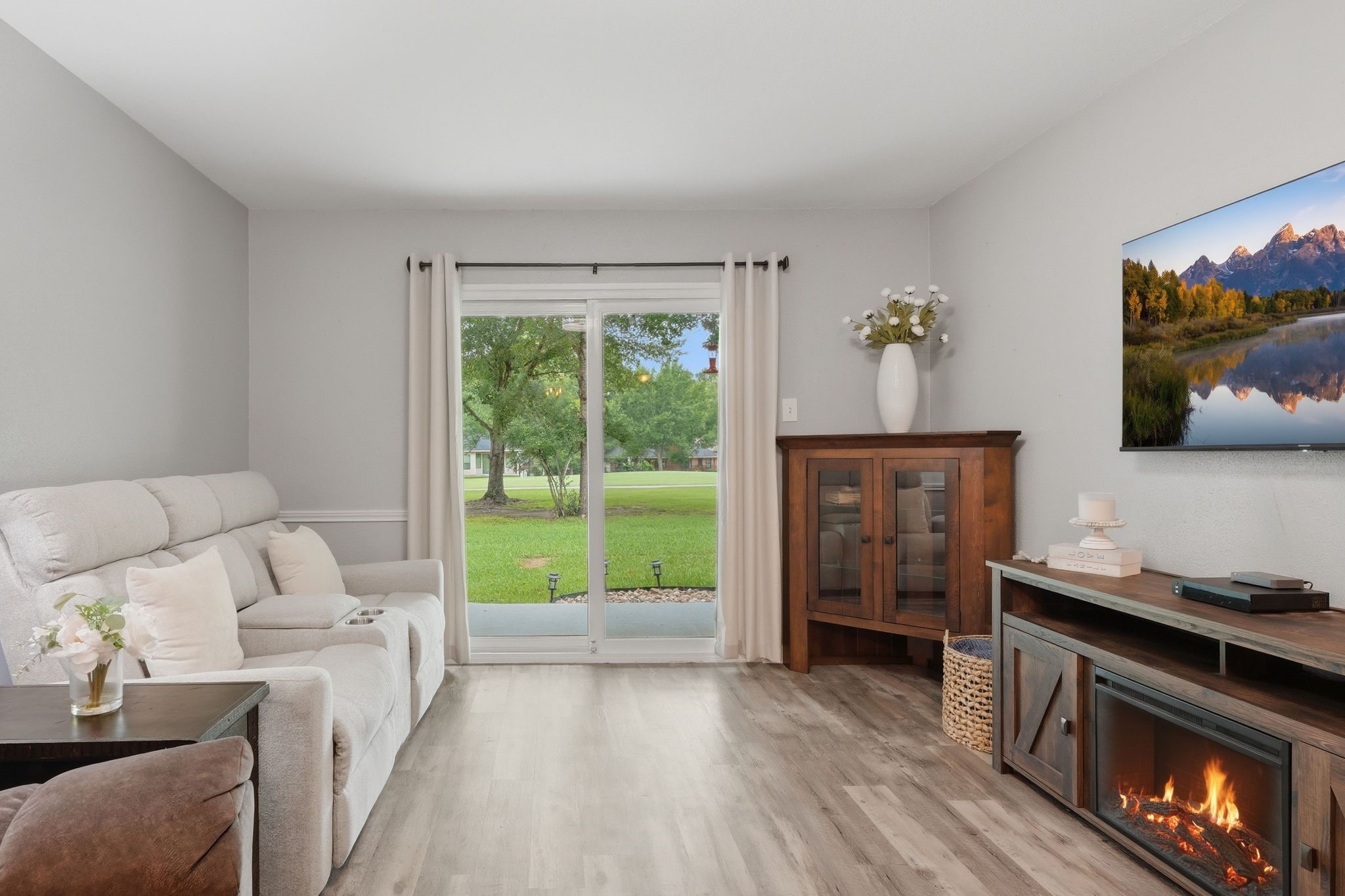 13151 Walden Road, Unit 131 Montgomery, TX 77356 - Photo 5 of 35 Cozy living room with a fireplace and large sliding doors to the patio.