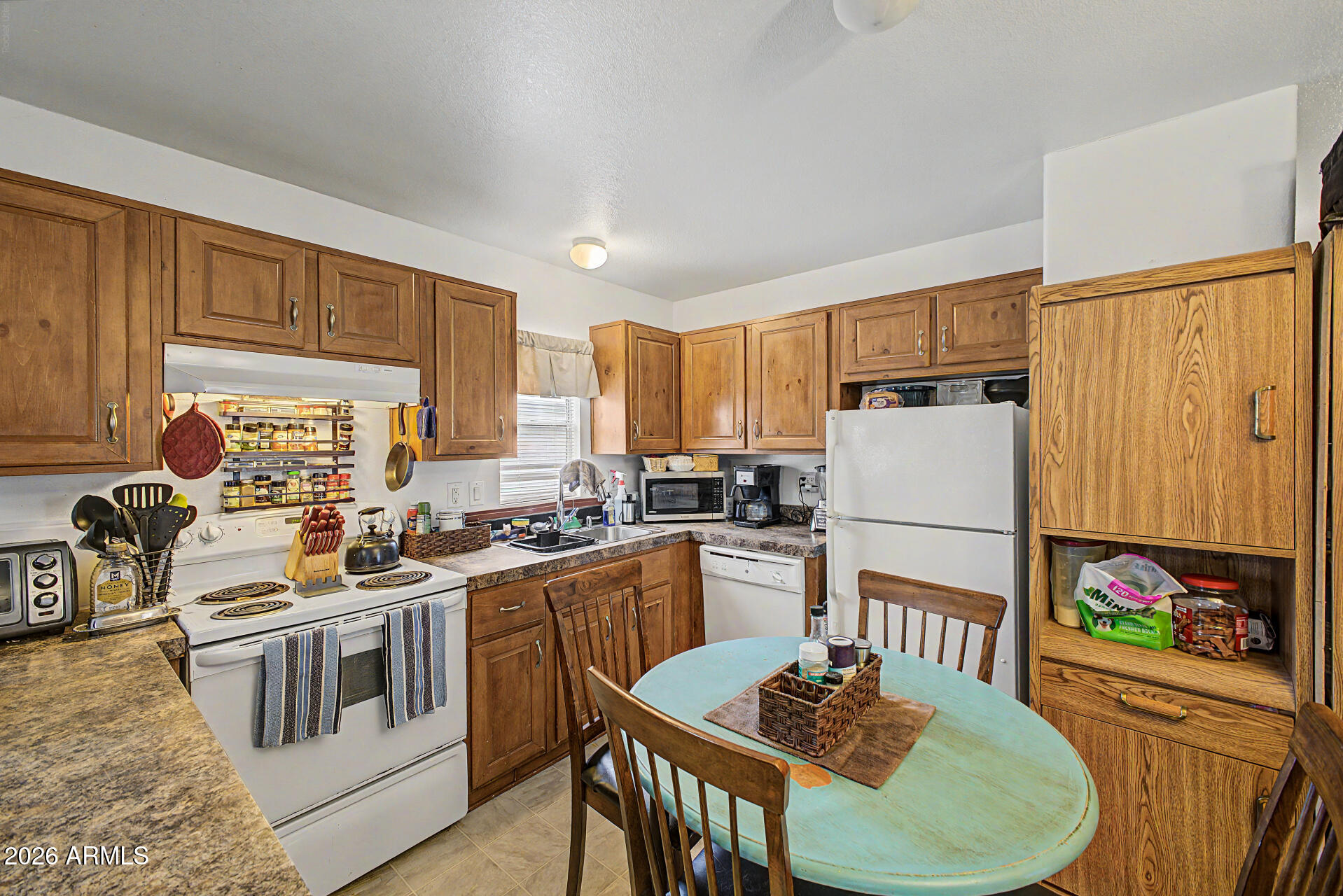 625 West McKellips Road, Unit 55 Mesa, AZ 85201 - Photo 9 of 21 a kitchen that has a stove a table and a refrigerator