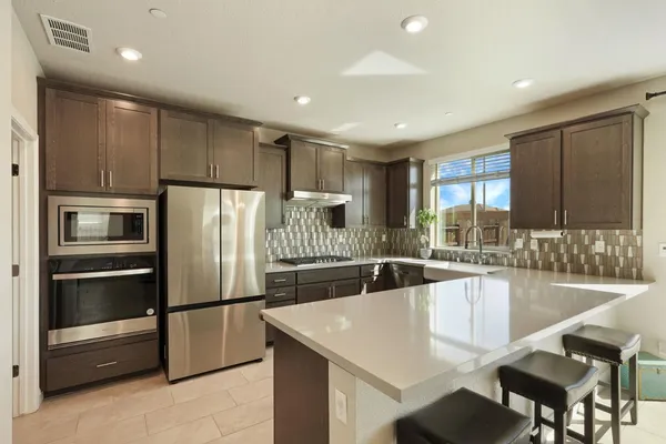 a kitchen with granite countertop a refrigerator and a sink