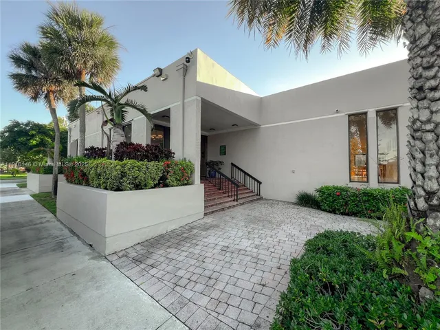 a view of a tennis ground with large trees