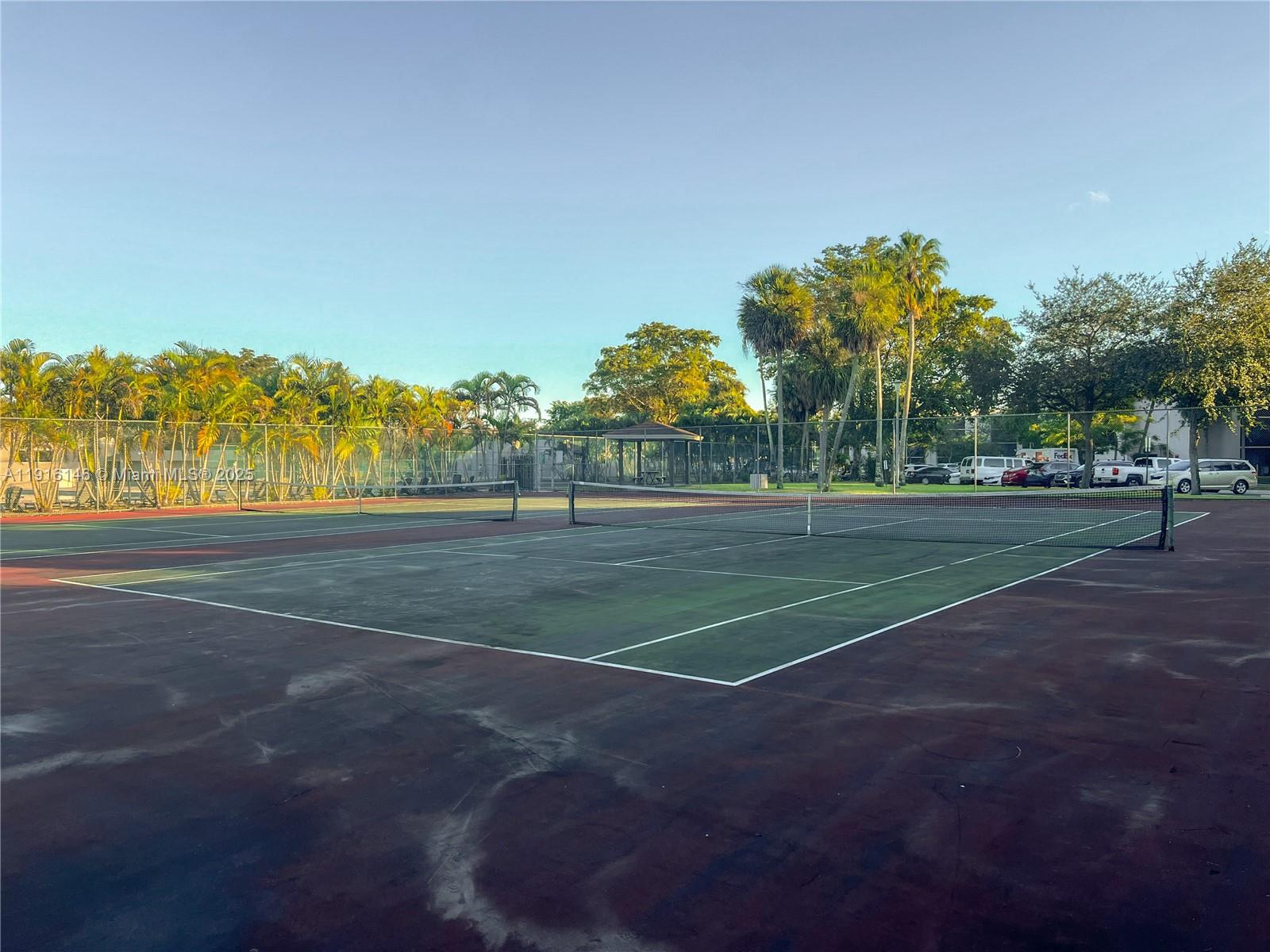 8600 Southwest 133rd Avenue Road, Unit 401 Miami, FL 33183 - Photo 25 of 31 a view of a tennis ground with large trees