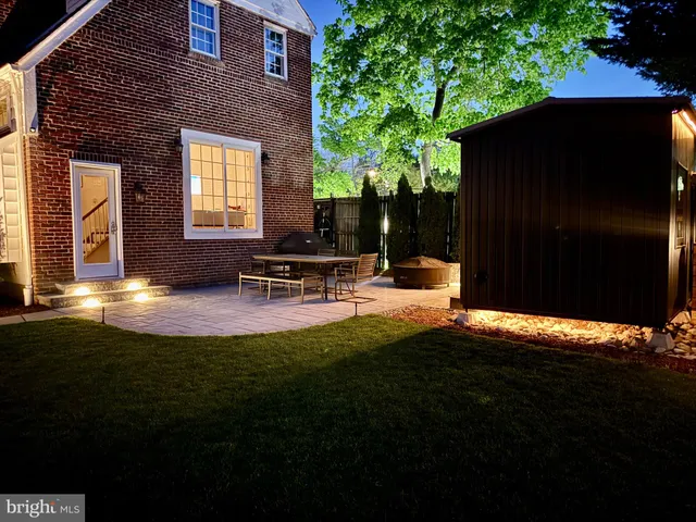 a backyard of a house with table and chairs with wooden fence