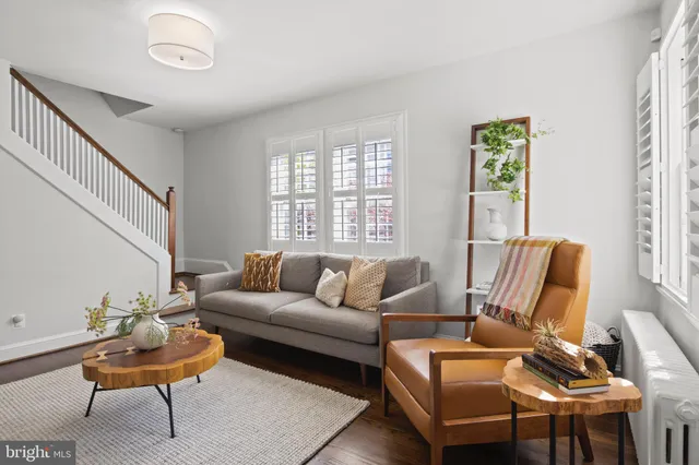 a kitchen with stainless steel appliances granite countertop a stove a sink a refrigerator white cabinets and wooden floor