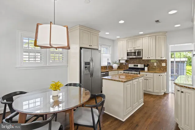 a kitchen with kitchen island granite countertop a stove sink and refrigerator
