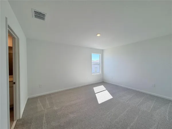 an empty room with a bench and windows