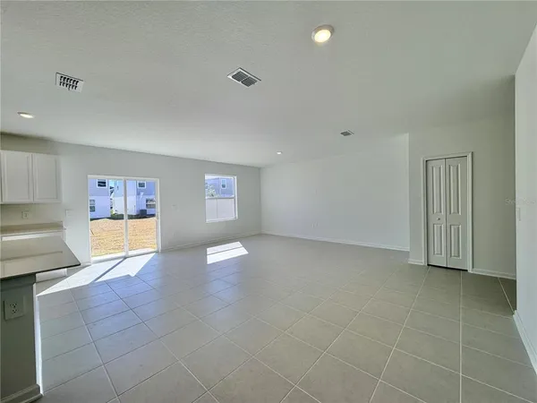 a large white kitchen with kitchen island a sink a stove a refrigerator and a cabinets
