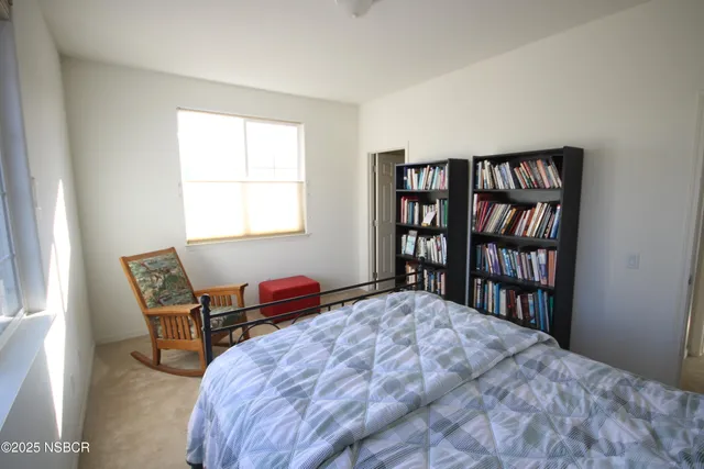 a bedroom with a bed and a book shelf
