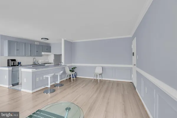 a living room with stainless steel appliances granite countertop a couch and cabinets