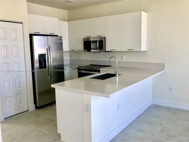 a kitchen with cabinets and stainless steel appliances