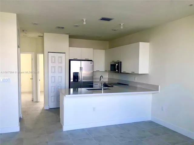 a kitchen with stainless steel appliances a sink stove and refrigerator