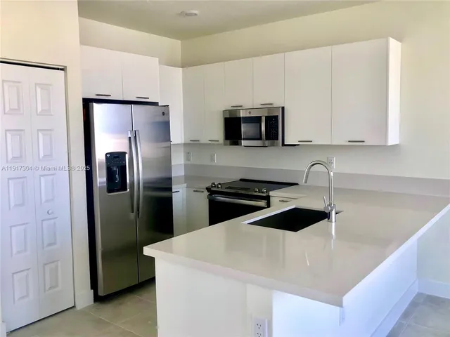 a kitchen with a refrigerator and a sink
