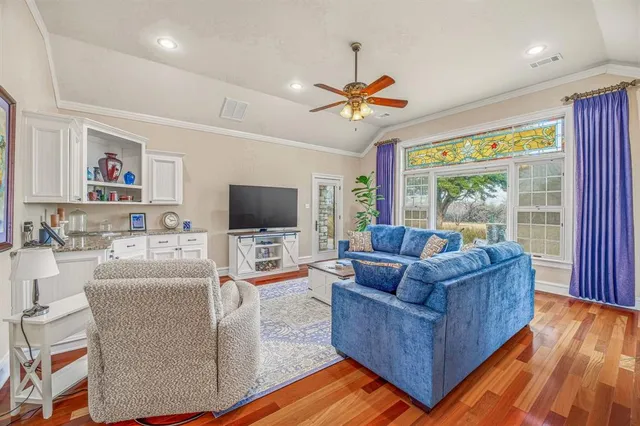 a living room with furniture a chandelier and a flat screen tv