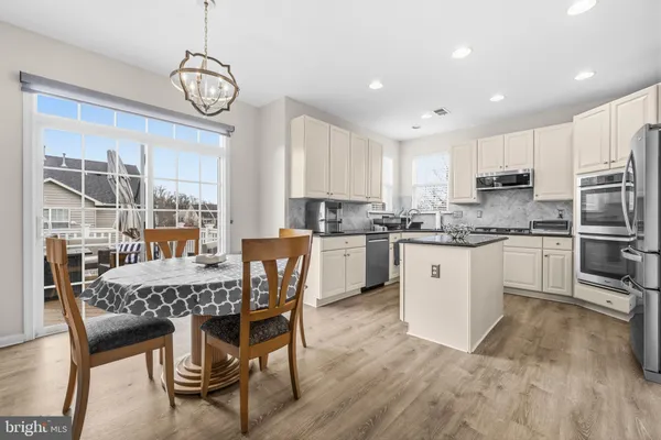 a kitchen with stainless steel appliances granite countertop a dining table chairs and granite counter tops