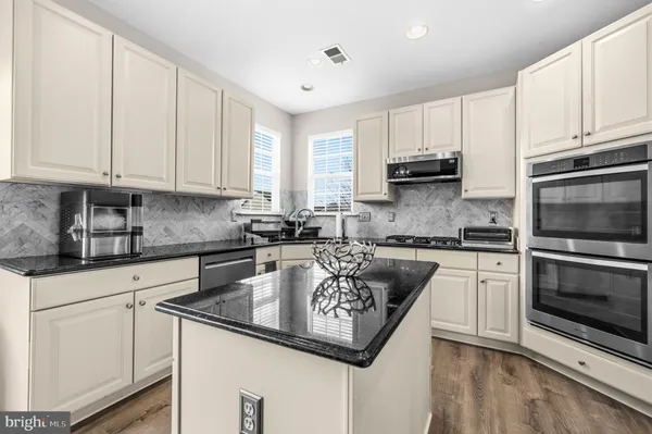 a kitchen with granite countertop a sink stove and cabinets