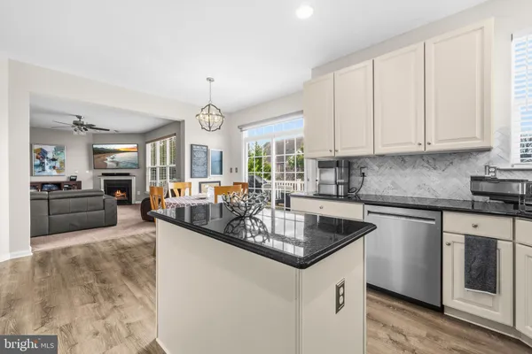 a kitchen with granite countertop a sink a stove top oven a counter space and cabinets
