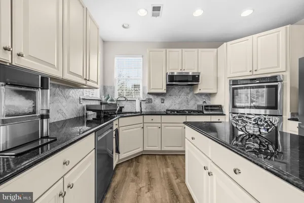 a kitchen with granite countertop a sink stove and cabinets