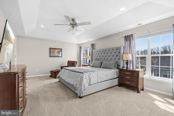 a bedroom with a large bed and a flat tv screen on dresser