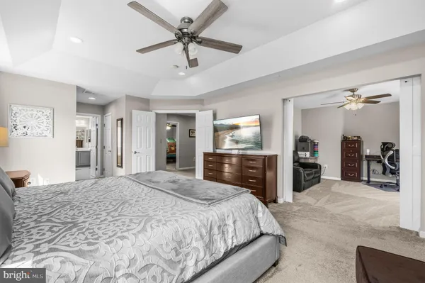 a spacious bedroom with a bed and a flat screen tv