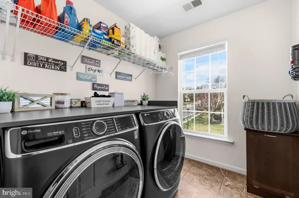 a utility room with stainless steel appliances washer and dryer