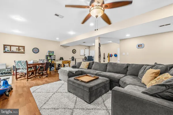 a living room with furniture kitchen view and a chandelier