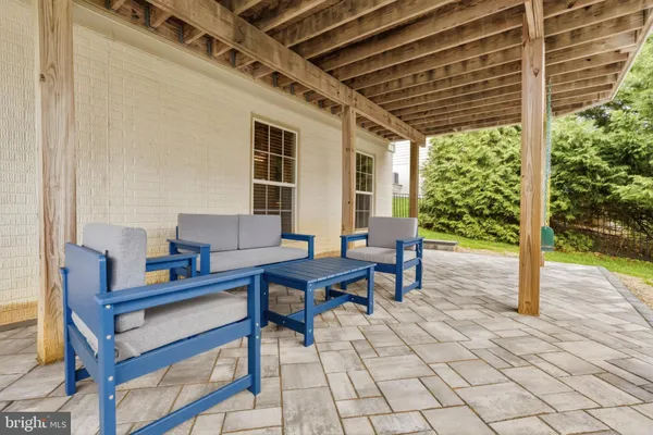 a view of a white building with a big yard and large trees