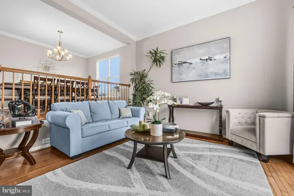 a living room with furniture a chandelier and a rug