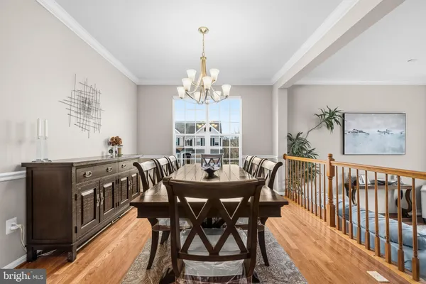 a view of a dining room with furniture wooden floor and chandelier