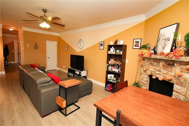 a living room with furniture a flat screen tv and a table
