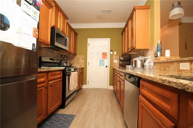 a kitchen with stainless steel appliances granite countertop a refrigerator a stove and a microwave