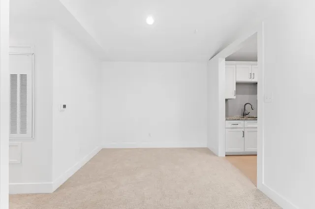 a view of a kitchen with white cabinets and dishwasher