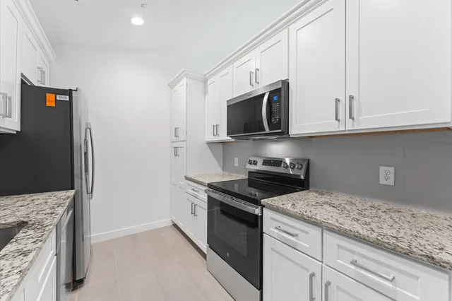 a kitchen with stainless steel appliances granite countertop a stove a microwave and a refrigerator