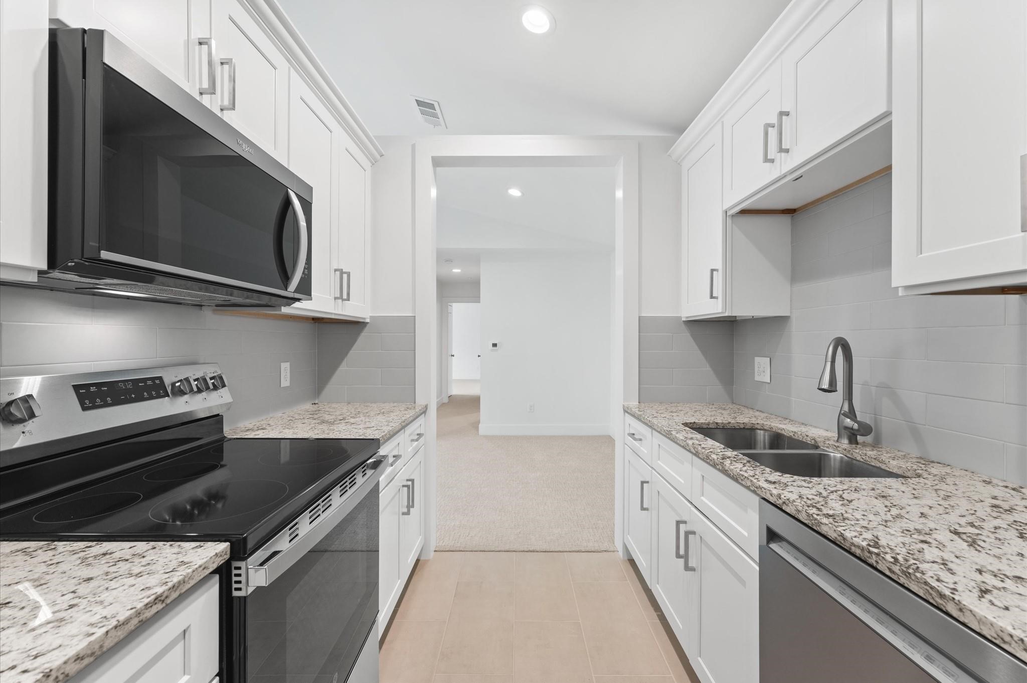 2829 Timmons Lane, Unit 202 Houston, TX 77027 - Photo 7 of 16 a kitchen with stainless steel appliances granite countertop a sink stove and microwave