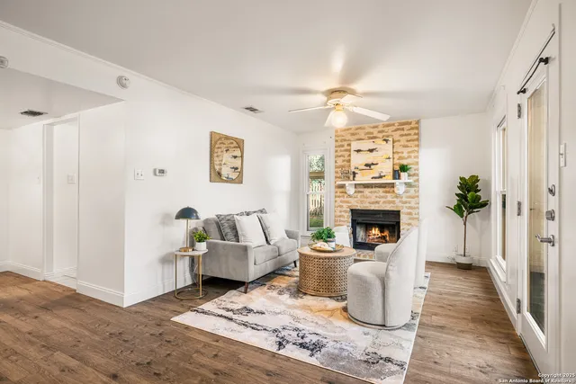 a living room with furniture a fireplace and a chandelier