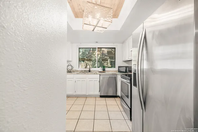 a kitchen with a refrigerator sink and cabinets