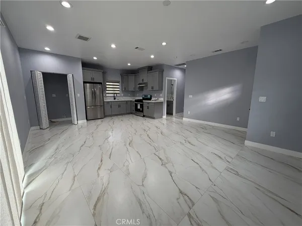 a view of a kitchen with a sink and a refrigerator
