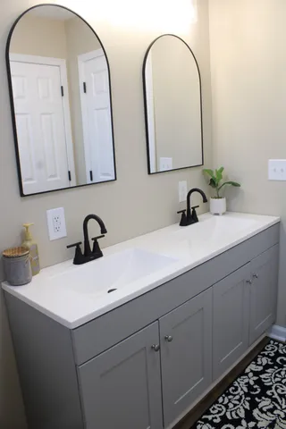 a bathroom with a double vanity sink and a mirror